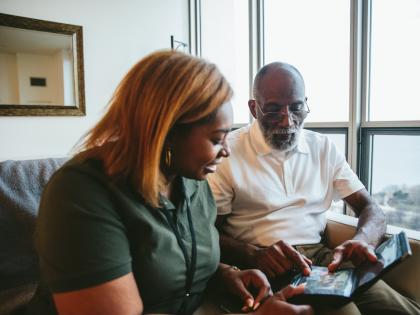 Home health aide and patient looking at photos